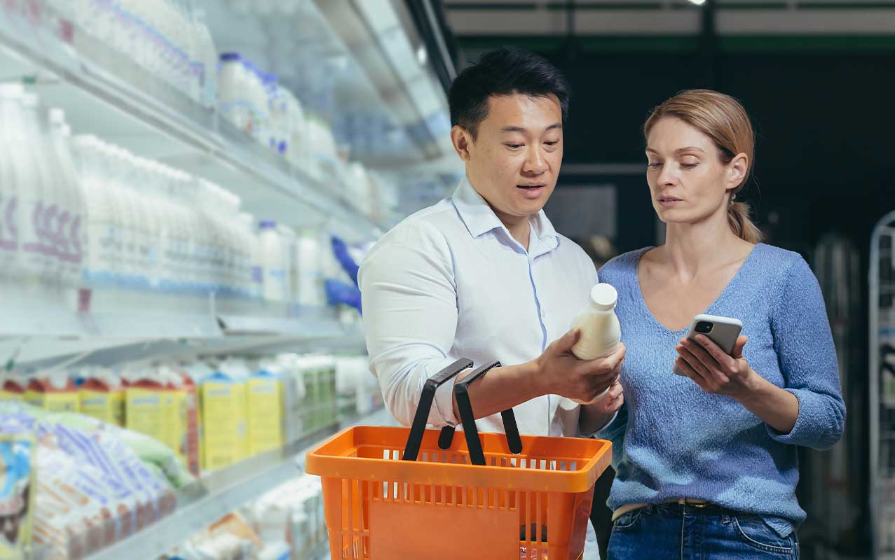 Man assisting blind woman with shopping